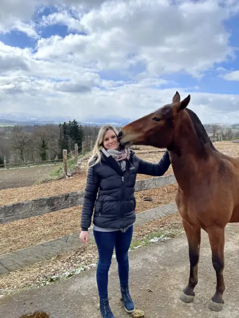 Angelina mit einem Pferd am Zaun