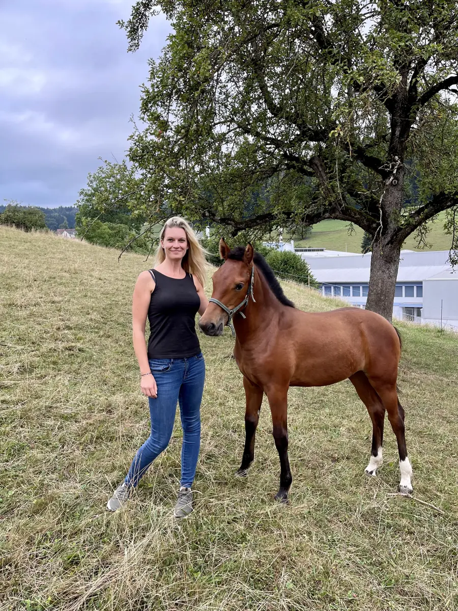 Angelina mit einem Jungpferd auf der Wiese